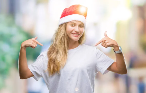 얼굴에 미소와 자신감 자부심과 손가락으로 자신을 가리키는 크리스마스 모자를 금발의 — 스톡 사진