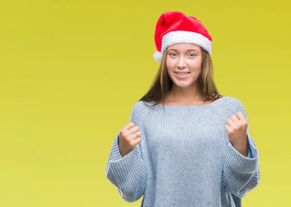 上孤立した背景を祝うクリスマスの帽子をかぶって若い美しい白人女性驚いて腕を上げると成功のため驚くし 目を開きます 勝者の概念 — ストック写真