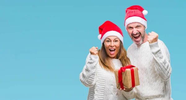 Coppia Ispanica Mezza Età Indossando Cappello Natale Tenendo Regalo Sfondo — Foto Stock