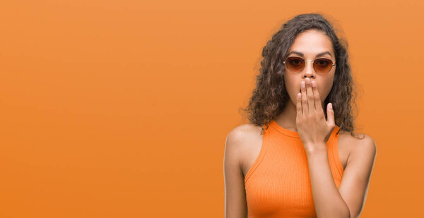 Young hispanic woman wearing summer outfit cover mouth with hand shocked with shame for mistake, expression of fear, scared in silence, secret concept