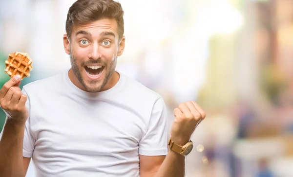 Joven Hombre Guapo Comiendo Dulce Waffle Sobre Fondo Aislado Gritando —  Fotos de Stock