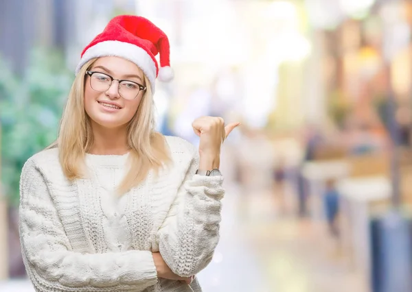 探していると親指側に上向きの幸せそうな顔を浮かべて隔離された背景にクリスマスの帽子をかぶって若い白人女性 — ストック写真