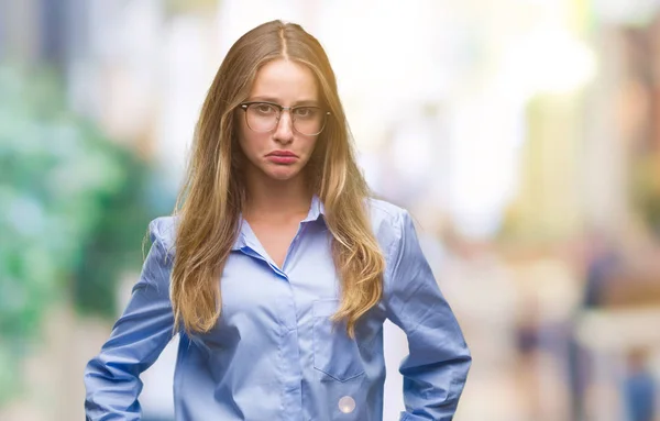 Young beautiful blonde business woman wearing glasses over isolated background depressed and worry for distress, crying angry and afraid. Sad expression.