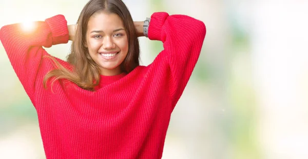 上赤冬のセーターを着ている若い美しいブルネットの女性は背景を分離したリラックスして腕と頭と首 幸せな笑顔の後ろに手を伸ばす — ストック写真