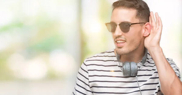 Guapo Joven Con Auriculares Sonriendo Con Mano Sobre Oído Escuchando —  Fotos de Stock