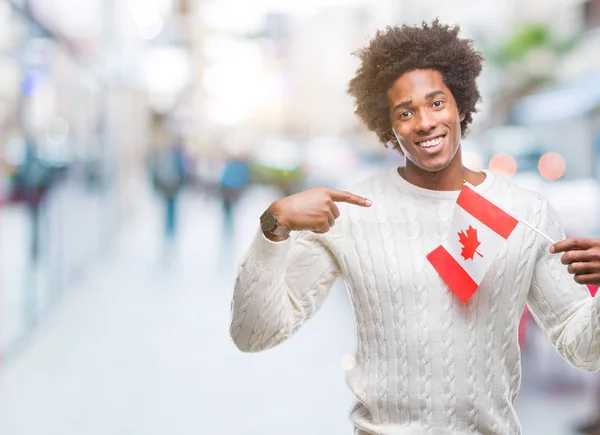 Afroamerikanischer Mann Flagge Kanadas Über Isoliertem Hintergrund Mit Überraschendem Gesicht — Stockfoto