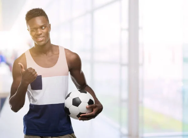 Joven Afroamericano Sosteniendo Pelota Fútbol Apuntando Con Mano Dedo Hacia —  Fotos de Stock