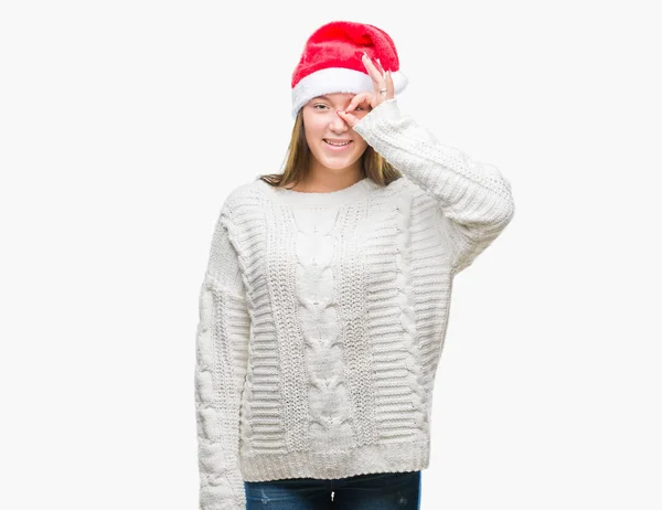 手の笑顔 幸せそうな顔で指を通して見る目で のジェスチャーを行う分離の背景にクリスマスの帽子をかぶって若い美しい白人女性 — ストック写真