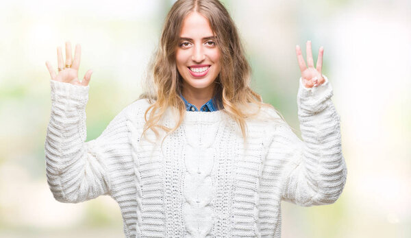 Beautiful young blonde woman wearing winter sweater over isolated background showing and pointing up with fingers number eight while smiling confident and happy.