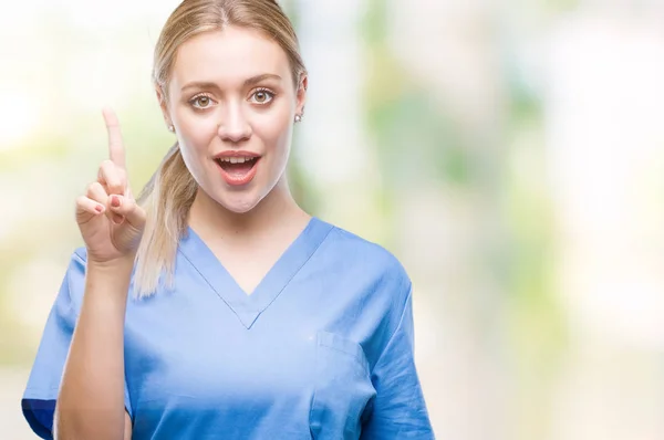 年轻的金发医生医生妇女穿医疗制服在孤立的背景指向手指与成功的想法 退出和快乐 第一个 — 图库照片