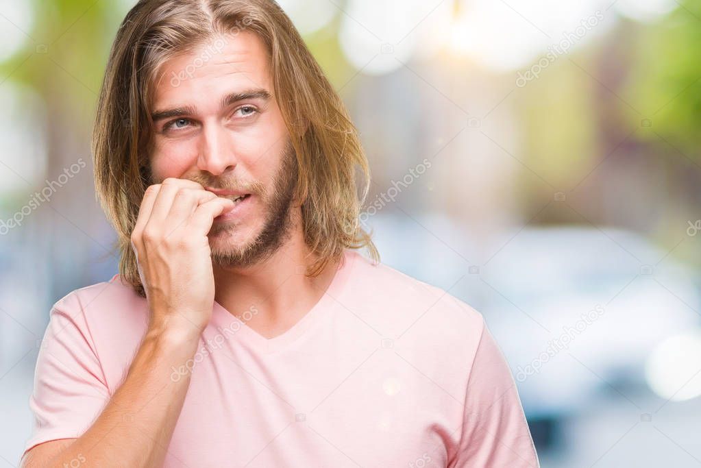 Young handsome man with long hair over isolated background looking stressed and nervous with hands on mouth biting nails. Anxiety problem.