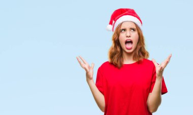Genç güzel kadın Noel şapka çılgın ve kızgın bağırarak ve agresif ifade ve silah kaldırdı bağırmaya izole arka plan yüzünden. Hayal kırıklığı kavramı.