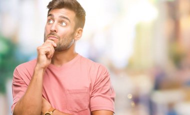 Yakışıklı delikanlı çene düşünme hakkında soru, dalgın ifade üzerine el ile izole arka plan üzerinde. Düşünceli yüzüyle gülümsüyor. Şüphe kavramı.