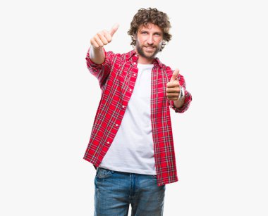 İzole arka plan onaylama üzerinden yakışıklı İspanyol modeli adam el ile pozitif jest yapıyor gülümseyen ve başarı için mutlu yaşasın. Kamera, kazanan jest arıyorsunuz.