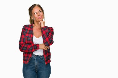 Çene düşünme hakkında soru, dalgın ifade üzerine el ile izole arka plan üzerinde rahat ceket giyen orta yaş yetişkin kadın. Düşünceli yüzüyle gülümsüyor. Şüphe kavramı.