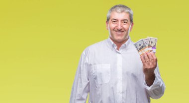 Yakışıklı komuta sizde para demet izole arka plan üzerinde duran ve diş gösterilen kendine güvenen bir gülümsemeyle gülümseyerek mutlu bir yüz ile tutarak