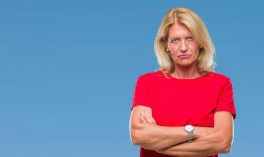 Orta yaş sarışın kadın izole arka plan şüpheci ve çapraz kolları olan yüzündeki gergin, onaylamayan ifade yüzünden. Negatif kişi.