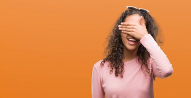 Güzel genç İspanyol kadın gülümsüyor ve gözleri için sürpriz kapsayan yüz el ile gülüyor güneş gözlüğü takıyor. Kör kavramı.