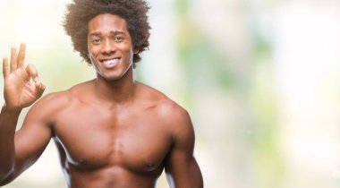 Çıplak vücut el ve parmaklar ok işaretiyle yapıyor olumlu gülümseyen izole arka plan üzerinde gösterilen Afro Amerikalı gömleksiz adam. Başarılı ifade.
