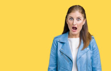 Güzel orta yaş Olgun kadın giyiyor moda deri ceket korkuyor ve şok sürpriz ifade ile izole arka plan üzerinde korku ve yüz heyecanlı.