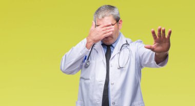 Yakışıklı kıdemli Doktor adam elleriyle gözlerini kapsayan izole arka plan üzerinde ve stop jest ile acı ve korku ifadesi. Utandım ve negatif kavramı.