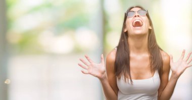 Genç güzel İspanyol kızgın ve silah ile başarı için deli kutluyor güneş gözlüğü takıyor kaldırdı ve heyecanlı çığlık gözler kapalı. Kazanan kavramı