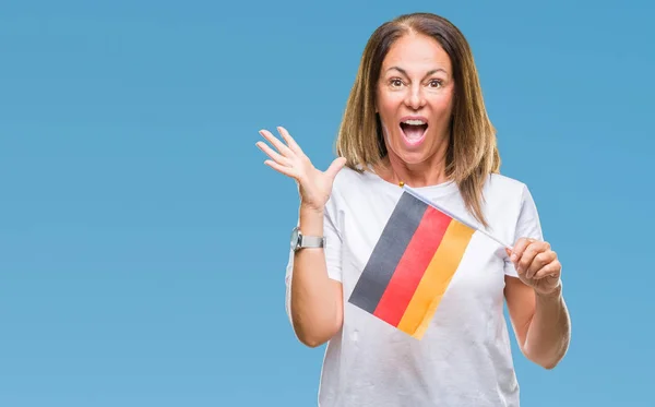 中年西班牙妇女拿着德国国旗在孤立的背景非常高兴和兴奋 获胜者的表情庆祝胜利尖叫着灿烂的笑容和举起的手 — 图库照片