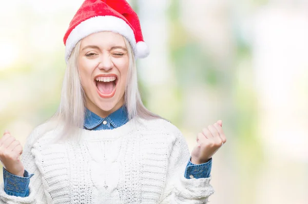 年轻的金发女子戴着圣诞节帽子在孤立的背景庆祝惊讶和惊讶的成功与双臂举起和睁开眼睛 获奖者概念 — 图库照片