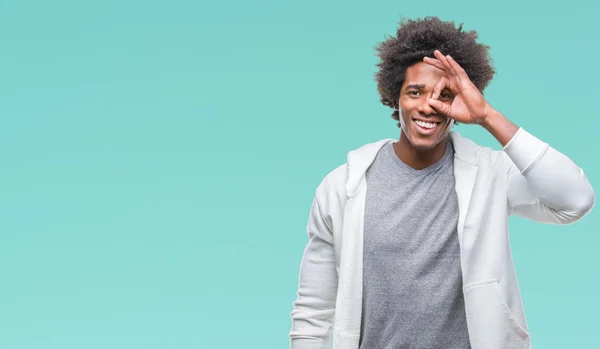美国黑人穿着运动衫在孤立的背景下做 手势用手微笑 眼睛看通过手指与愉快的面孔 — 图库照片
