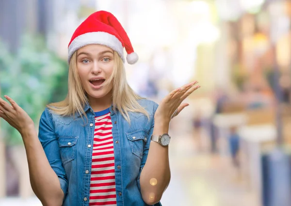若い白人女性をクリスマスの帽子をかぶって狂気を祝う背景を分離した腕を上げると成功のためびっくりし 叫んで興奮して目を開きます 勝者の概念 — ストック写真