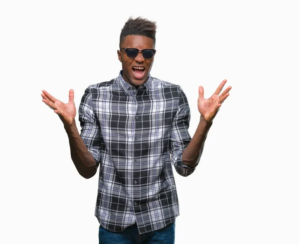 サングラスをかけている若いアフリカ系アメリカ人は狂気を祝う背景を分離し 腕の成功のため驚いて叫んで興奮発生と開いた目 勝者の概念 — ストック写真