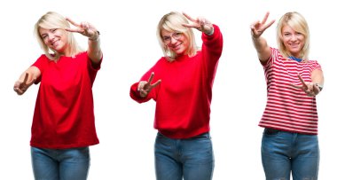 Kolaj bir zafer işareti yapıyor parmak gösterilen kamera seyir gülümseyen izole arka plan üzerinde rahat kırmızı giyen güzel sarışın kadın. İki numaralı.