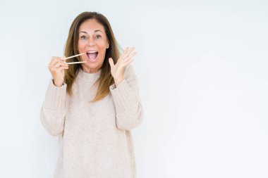 Asya yemek çubukları ile büyük gülümseme çığlık ve ellerini kaldırdı zaferini kutluyor izole arka plan çok mutlu ve heyecanlı, kazanan ifade üzerinde tutan orta yaş kadın