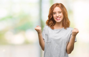 İzole arka plan kutlama üzerinde genç güzel kadın şaşırttı ve başarı için kaldırdı kollarını açarak hayret ve gözleri açık. Kazanan kavramı.