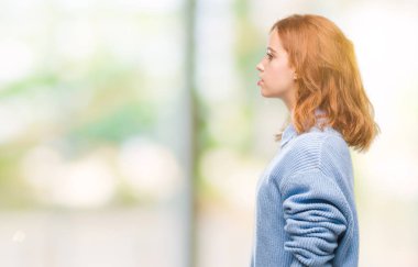 İzole arka tarafına, seyir kış kazak giyen genç güzel kadın dinlenmek doğal yüz emin gülümseme ile pozuyla profili.