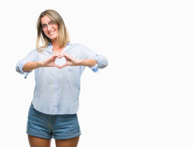 Genç güzel iş kadını aşık kalp simgesi ve elleriyle şekil gösteren gülümseyen izole arka plan üzerinde. Romantik kavramı.