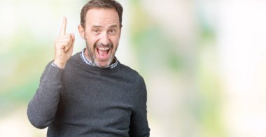 Yakışıklı orta yaş komuta sizde başarılı fikirle izole arka plan üzerinde işaret parmağı bir kazak giyiyor. Çıktıktan ve mutlu. Bir numara.