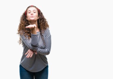 Güzel esmer kıvırcık saçlı Genç kız bir öpücük el ile güzel ve seksi olmak hava üfleme kamera bakarak izole arka plan üzerinde çizgili kazak giyiyor. Aşk ifade.