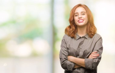 İzole arka plan mutlu yüz çapraz silah kameraya bakarak ile gülümseyen genç güzel kadın. Olumlu bir kişi.