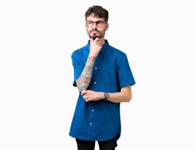 Çene düşünme hakkında soru, dalgın ifade üzerine el ile izole arka plan üzerinde gözlük takan yakışıklı delikanlı. Düşünceli yüzüyle gülümsüyor. Şüphe kavramı.