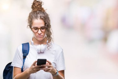 Sırt çantası, kulaklık ve smartphone acımak yüz ciddi düşünüyorum üstünde kendine güvenen bir ifade ile izole arka plan üzerinde giyen genç esmer öğrenci kız