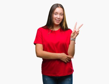 Genç güzel beyaz bir kadın mutlu yüz zafer işareti yaparken kameraya göz kırpıyor ile gülümseyen izole arka plan üzerinde. İki numaralı.