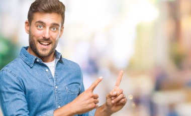 Yakışıklı delikanlı gülümseyen ve iki elleri ve parmakları ile tarafına işaret kamera bakarak izole arka plan üzerinde.