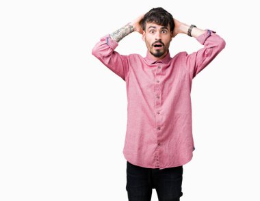 Genç yakışıklı adam giymiş pembe gömlek üzerinde arka plan deli izole ve baş, korkuyor ve açık ağzı ile şok sürpriz elleriyle korkuttu