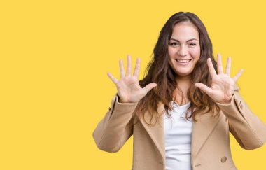 Parmakları ile number ten kendinden emin ve mutlu gülümseyerek süre güzel artı boyutu genç kadın giyiyor kış ceket ve yukarıyı gösteren izole arka plan üzerinde.