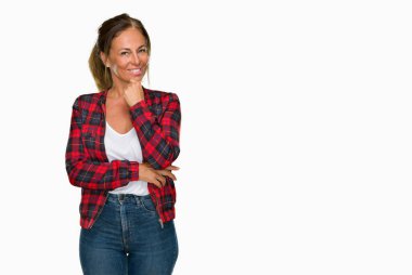 Emin çapraz kollar ve çeneme kaldırdı el ile gülümseme ile kameraya bakarak izole arka plan üzerinde rahat ceket giyen orta yaş yetişkin kadın. Pozitif düşünce.