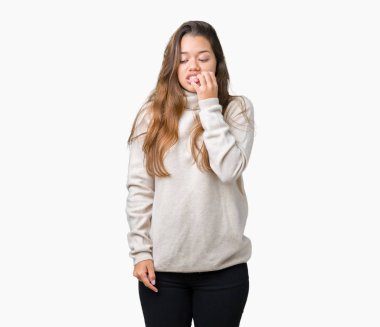 Stresli ve gergin ile izole arka plan üzerinde boğazlı kazak giyen genç güzel esmer kadın tırnak ısırma dudaklarından eller. Anksiyete sorunu.