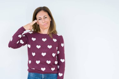 Güzel orta yaş kadın giyiyor kalp kazak izole üzerinde çekim ve öldürmek kendini el ve parmaklara baş, intihar jest işaret arka plan.