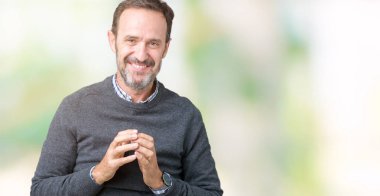 Üzerinde bir kazak giyen yakışıklı orta yaş üst düzey adam arka plan eller birlikte izole ve rahat ve neşeli gülümseyen parmak çarpı işareti. Başarı ve iyimser