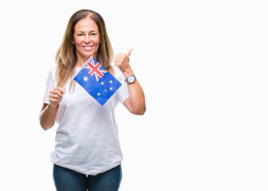 Avustralya bayrağı işaret ve başparmak kadar mutlu yüz gülümseyen tarafı ile gösteren izole arka plan üzerinde tutan orta yaş İspanyol kadın